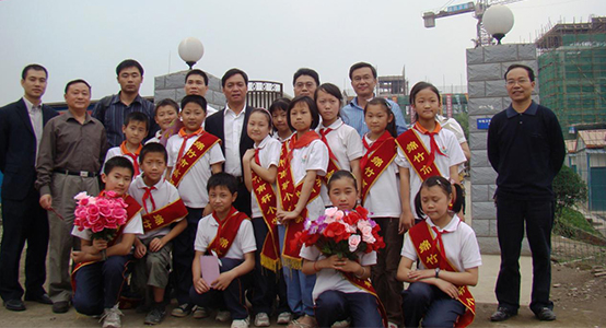陈卓林一行和尊龙凯时捐建的南轩小学学生合影